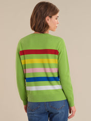 Person wearing a green sweater with colorful horizontal stripes on a beige background