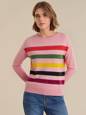 Woman wearing a pink sweater with colorful horizontal stripes on a beige background