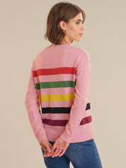 Woman wearing a pink sweater with colorful horizontal stripes on a beige background