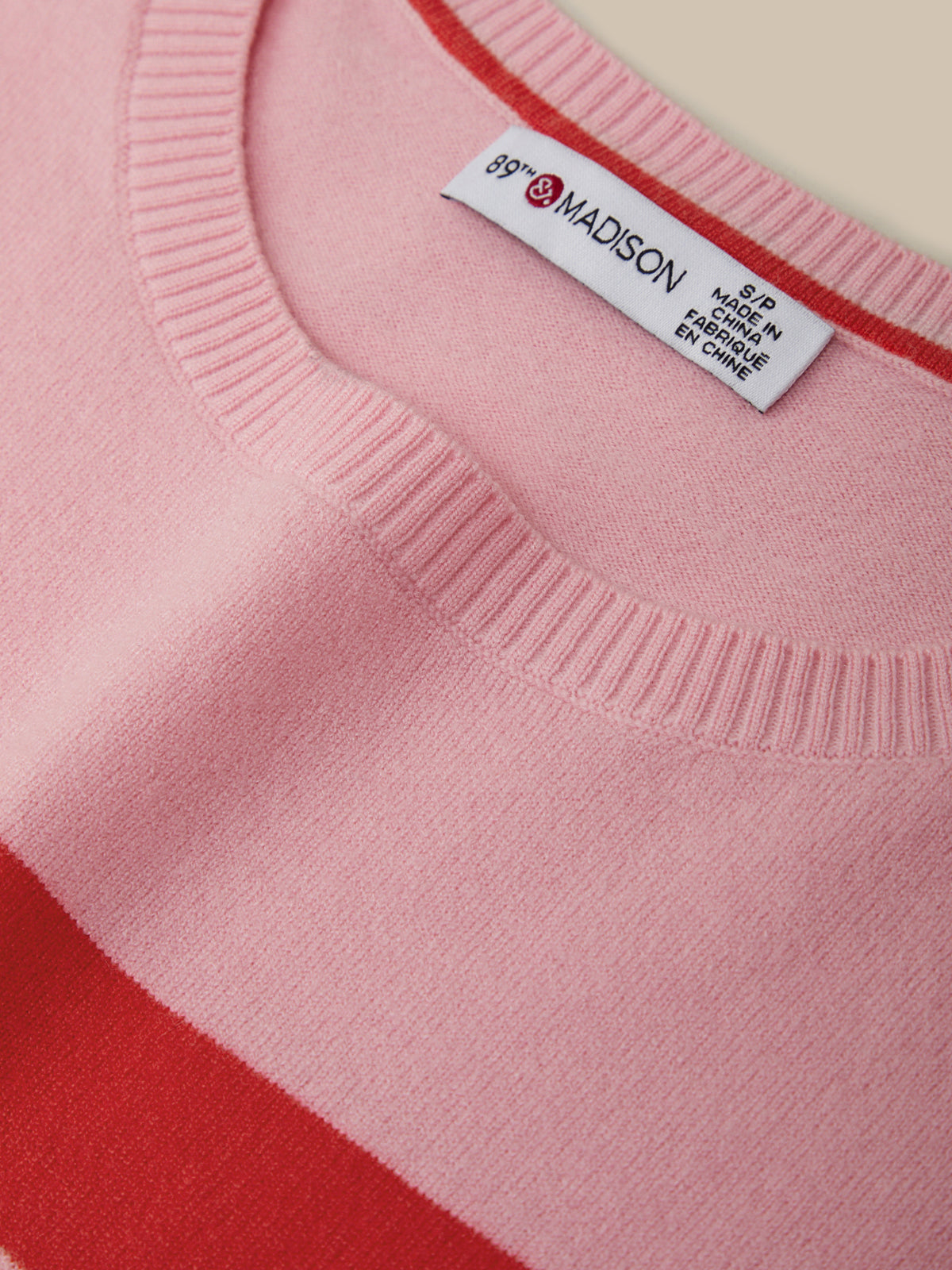 Close-up of a pink sweater with a visible label