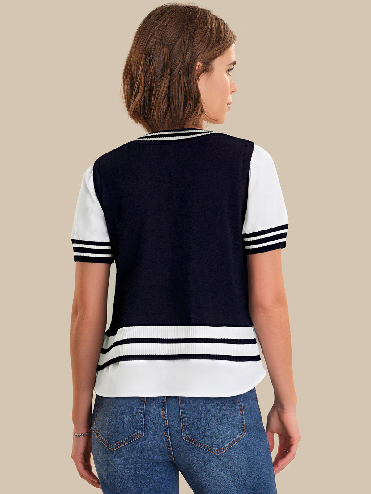 Woman wearing a navy and white striped shirt with blue jeans on a beige background