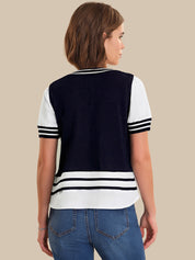 Woman wearing a navy and white striped shirt with blue jeans on a beige background