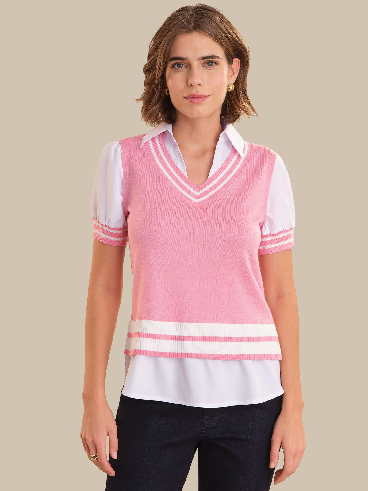 Woman wearing a pink and white striped sweater vest over a white shirt on a beige background