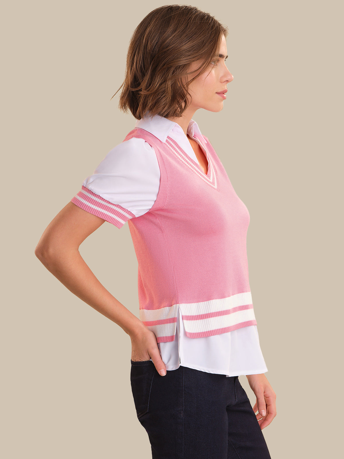 Woman wearing a pink and white blouse with a beige background