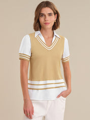 Woman wearing a beige and white striped sweater vest over a white shirt on a beige background