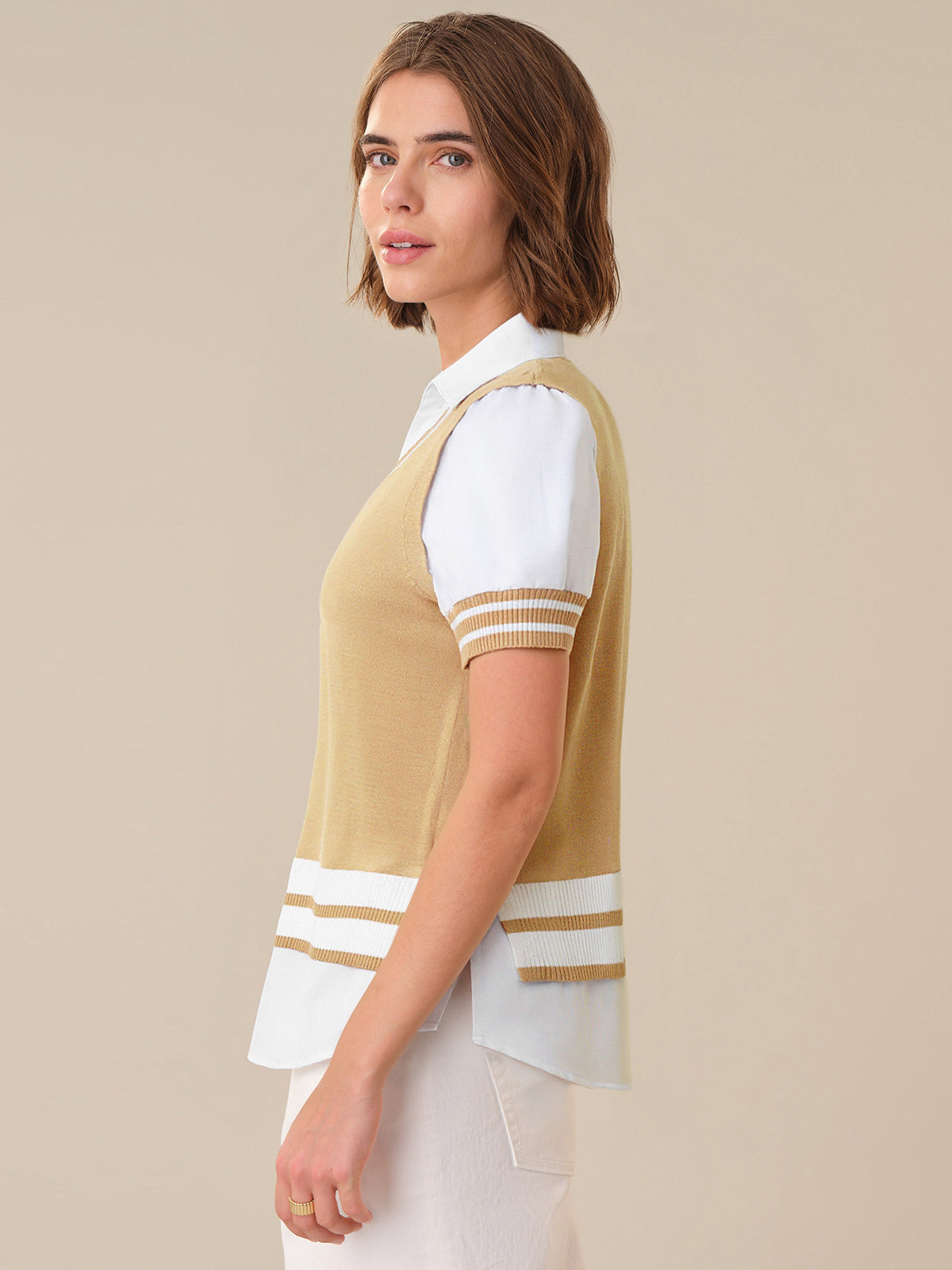 Woman wearing a beige and white striped shirt with a plain background
