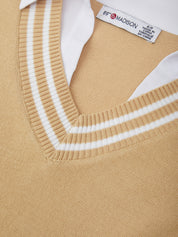 Close-up of a beige sweater with white trim and a visible label.