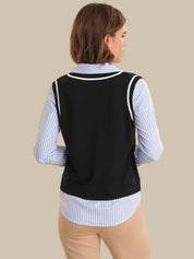 Woman wearing a black vest over a striped shirt on a beige background