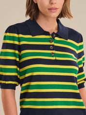 Person wearing a green and yellow striped polo shirt with a navy collar.