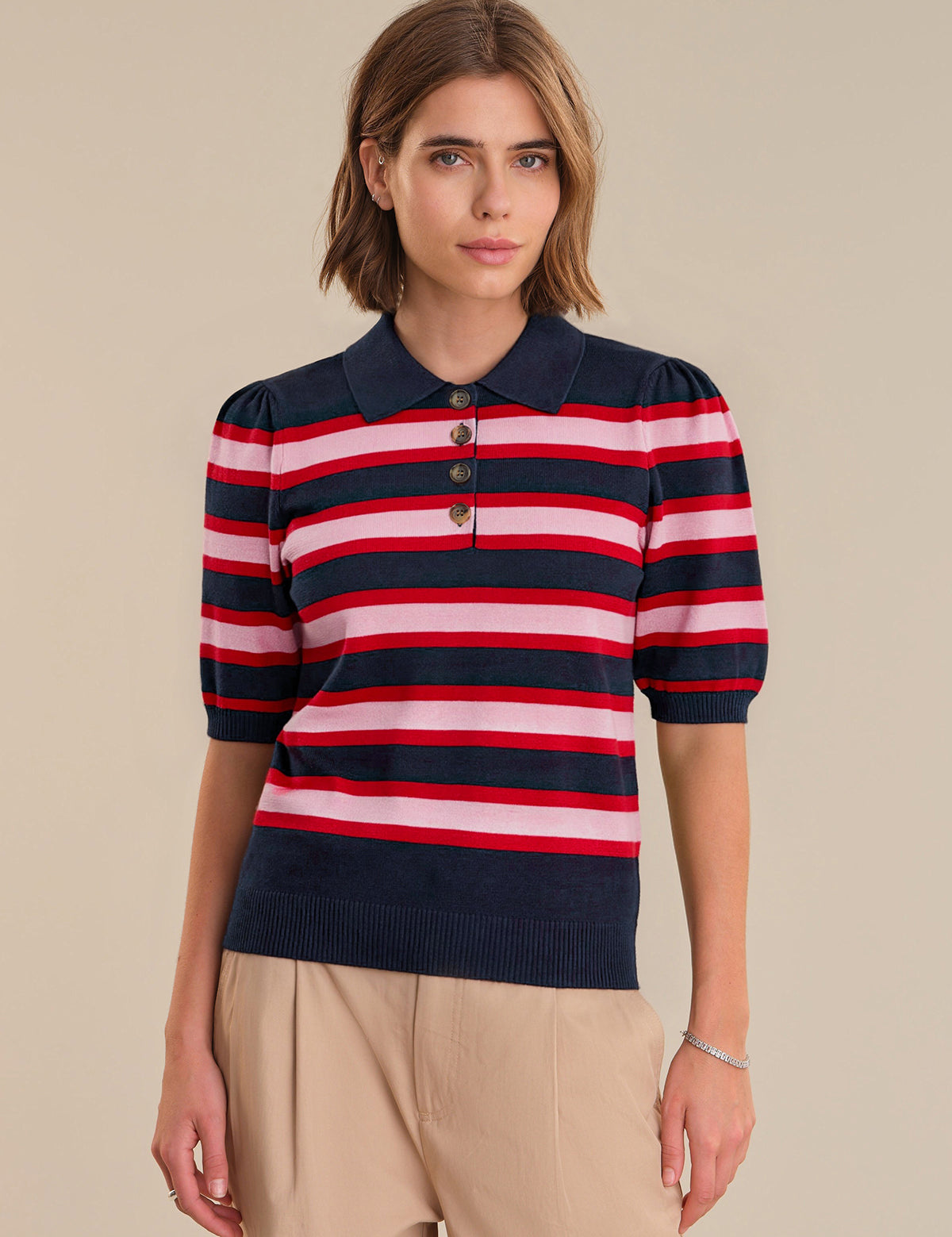 Woman wearing a striped sweater with a beige background