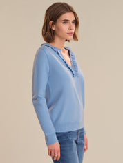 Woman wearing a light blue sweater with a beige background