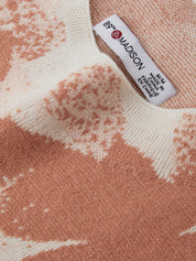 Close-up of a textured fabric with a Madison label on a pink and white patterned background