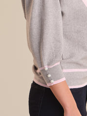 Gray sweater with pink trim on a neutral background