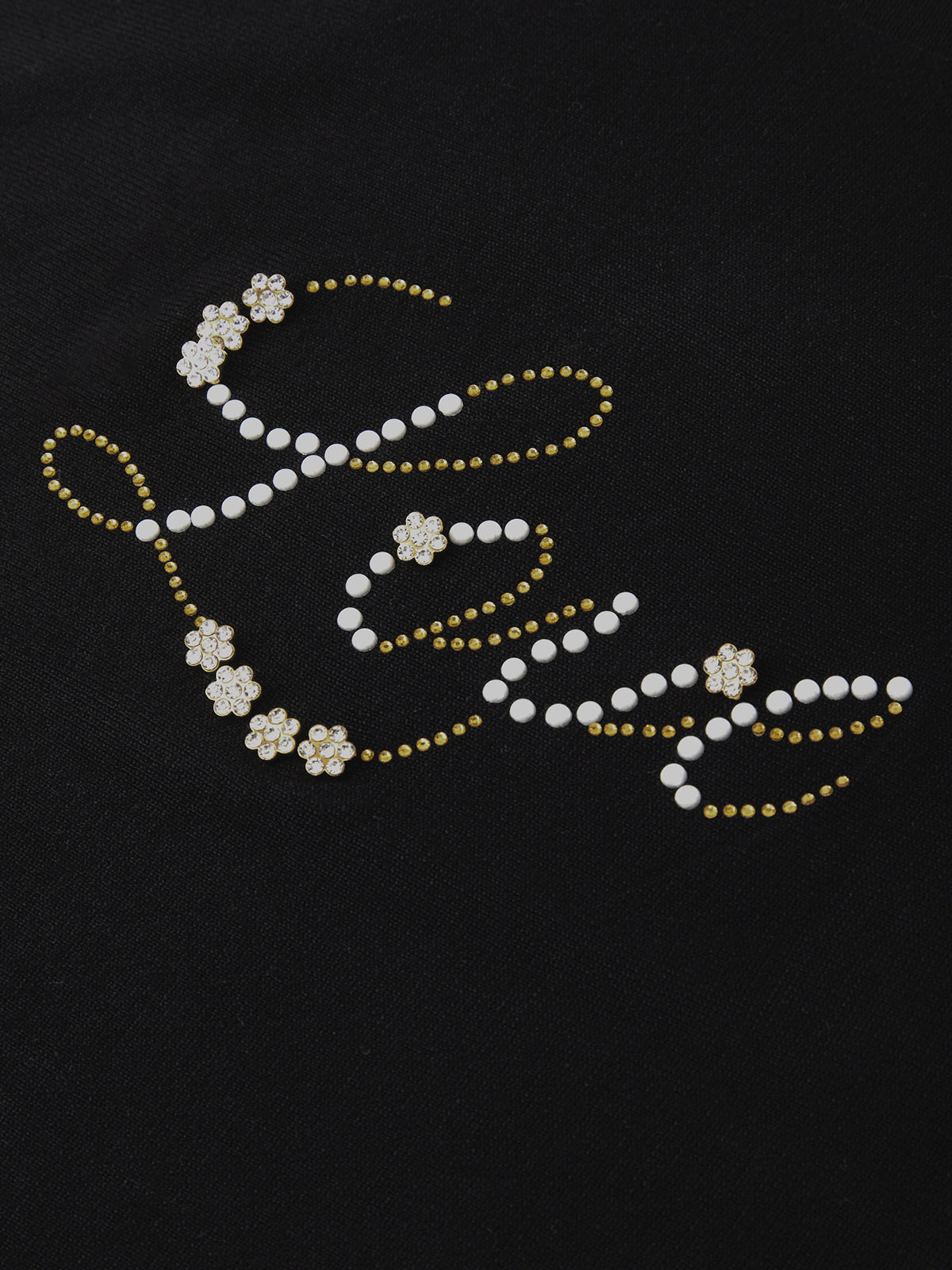 Decorative word with pearls and gold accents on a black background