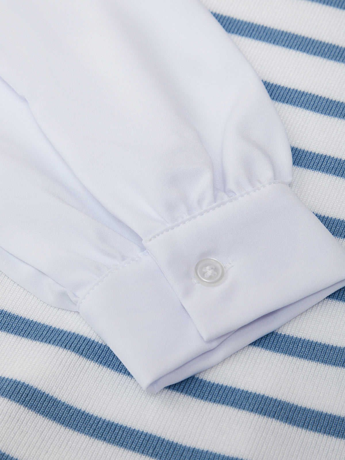 White shirt collar on a blue and white striped fabric background