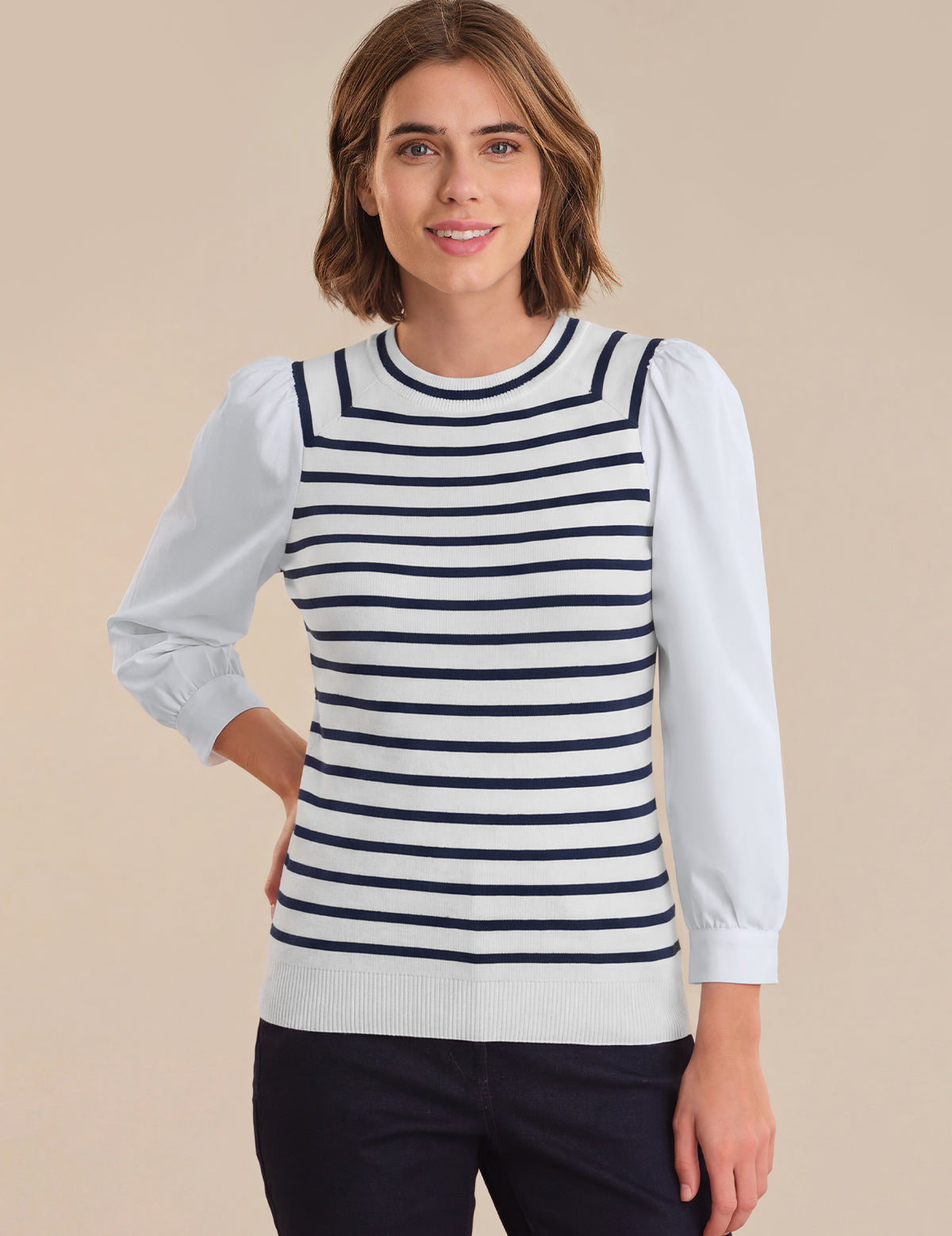 Woman wearing a striped sweater with a plain background