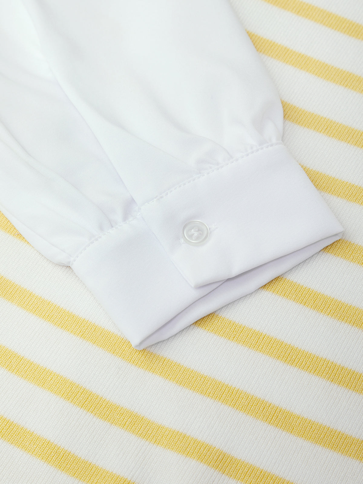 White shirt collar on a yellow and white striped fabric background