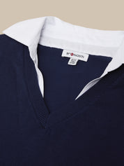 Navy sweater with white collar and visible brand label on a beige background