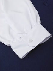 Close-up of a white shirt cuff on a dark background