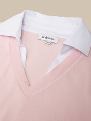 Pink sweater with a white shirt collar and 'Madison' label on a beige background