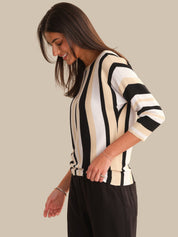Woman wearing a black and white striped sweater against a plain background