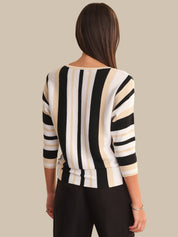 Woman wearing a black and beige striped sweater against a neutral background