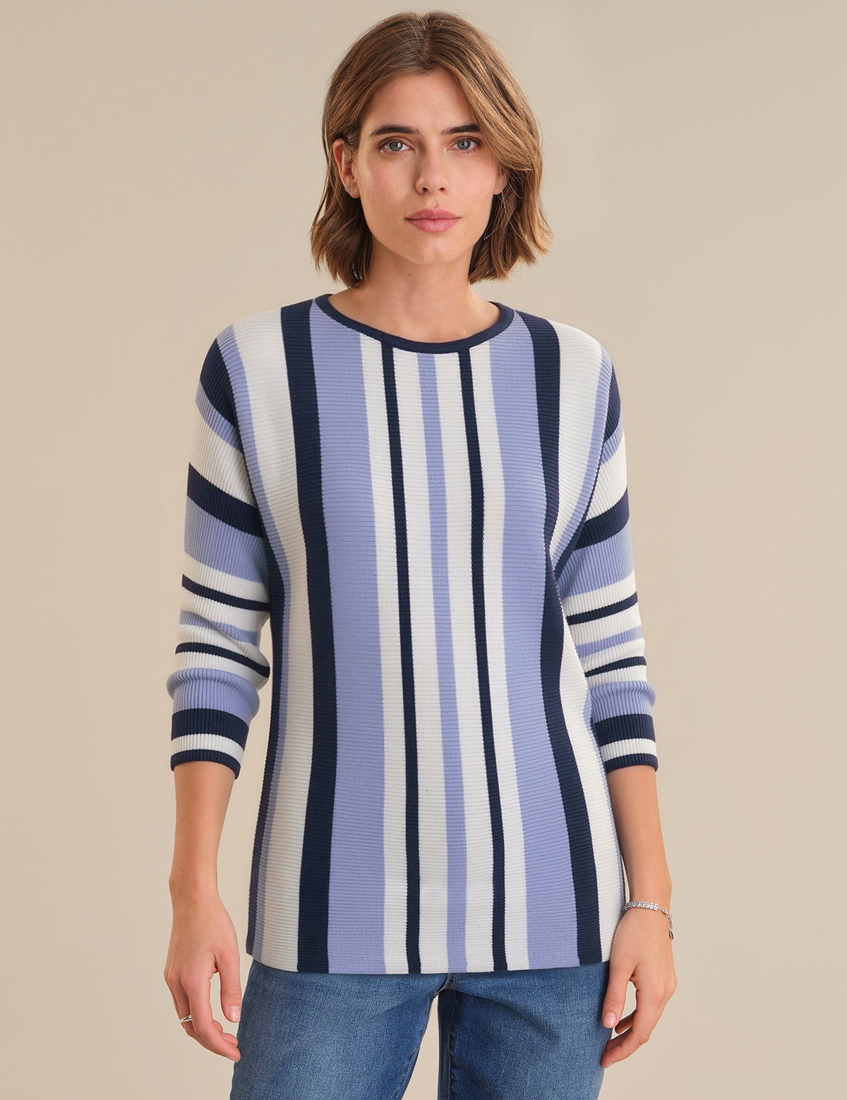 Woman wearing a blue and white striped sweater against a beige background