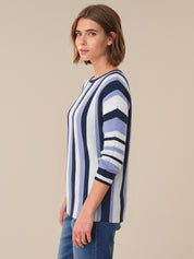 Woman wearing a striped sweater against a beige background