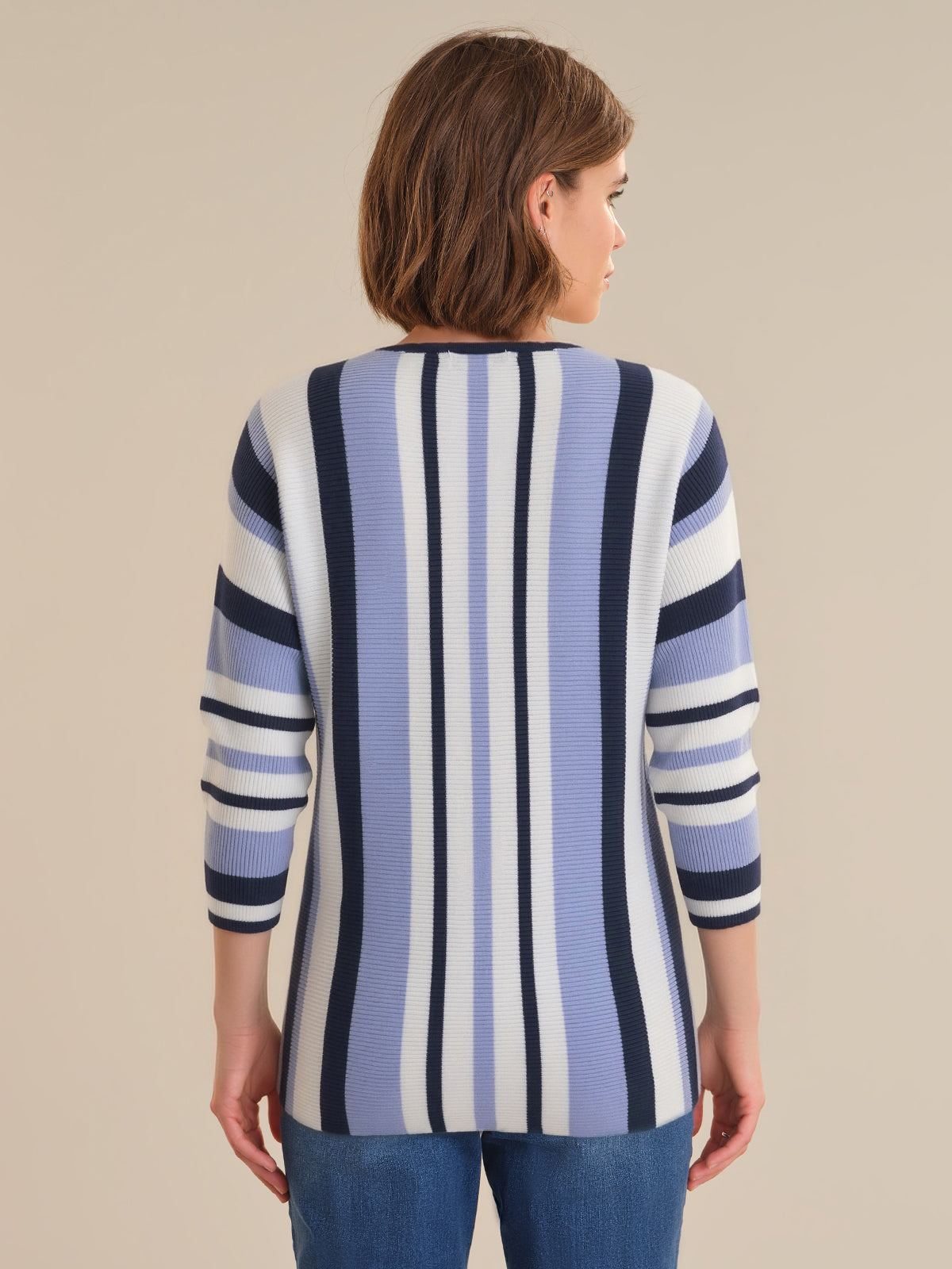 Woman wearing a striped sweater with a neutral background