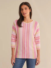 Woman wearing a pink and yellow striped sweater against a beige background