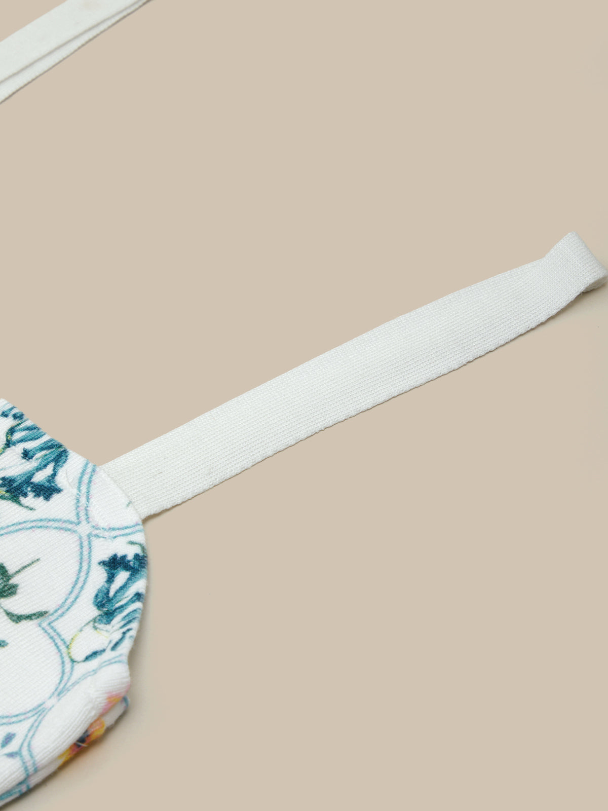 Fabric with floral pattern and white strap on a beige background