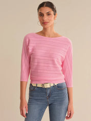 Woman wearing a pink sweater and blue jeans on a beige background