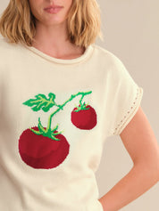 White t-shirt with red tomato design on a plain background