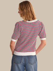 Woman wearing a red, white, and blue striped shirt with a beige background