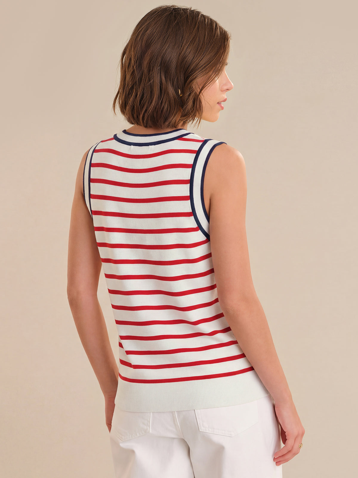 Woman wearing a red and white striped sleeveless top on a beige background