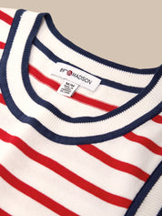 Close-up of a red, white, and blue striped sweater with a label on a beige background