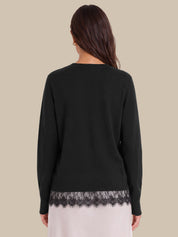 A woman shown from the back wearing a black long-sleeve top with a black lace hem, paired with a light pink skirt, against a solid beige background.