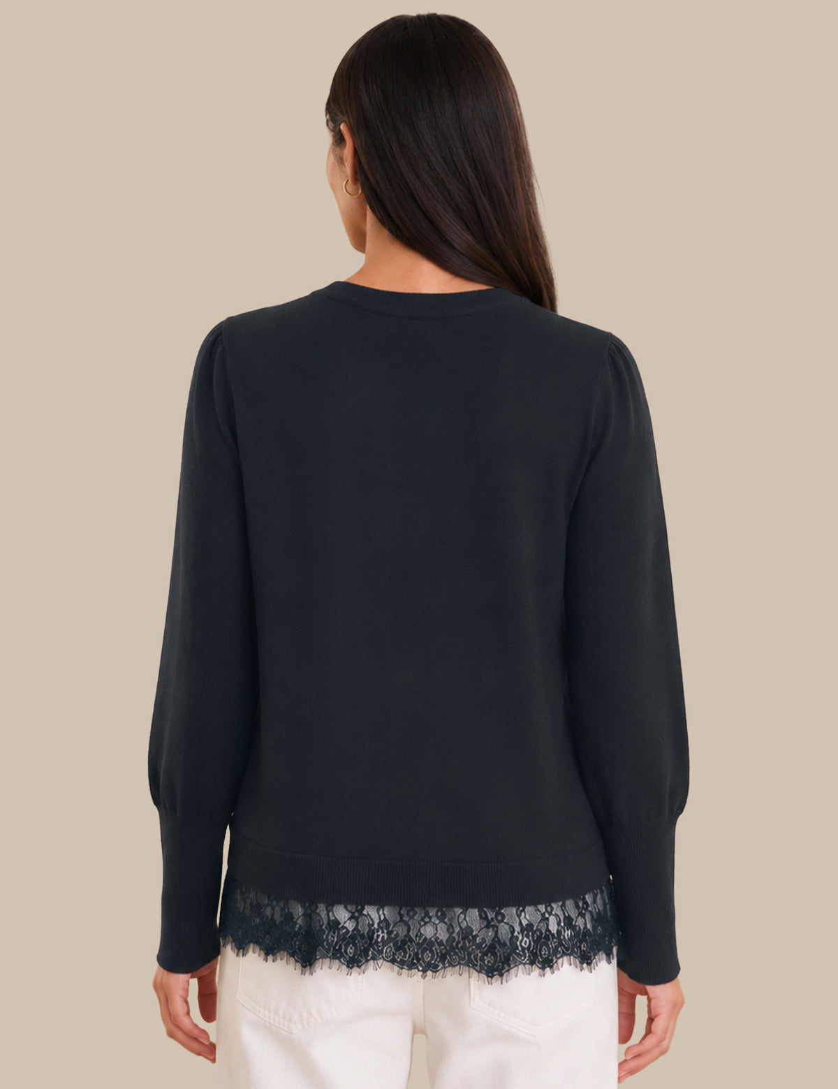 Woman wearing a black sweater with lace trim on a beige background