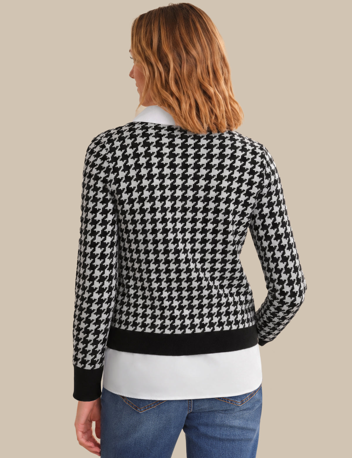 Person wearing a black and white houndstooth patterned sweater on a beige background