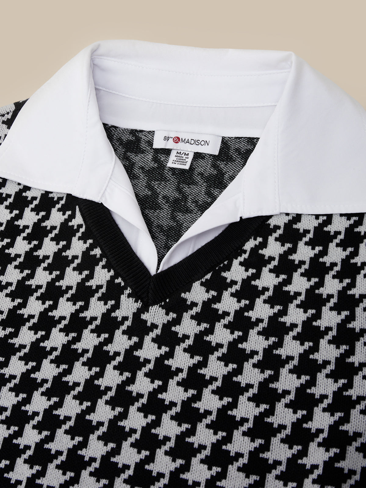 Close-up of a houndstooth patterned shirt with a white collar and '5th Avenue' label.