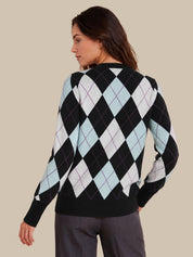 A woman shown from the back wearing a black sweater with a light blue, white, and black argyle pattern, paired with dark gray trousers, against a solid beige background.