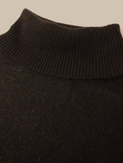 Close-up of a dark brown ribbed knit turtleneck sweater, showing the texture of the collar and fine knit details against a light beige background.