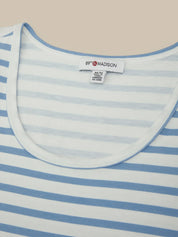 Close-up of a blue and white striped shirt with a brand label on a beige background