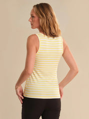 Woman wearing a yellow striped tank top against a beige background