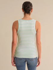 Person wearing a green and white striped tank top on a beige background