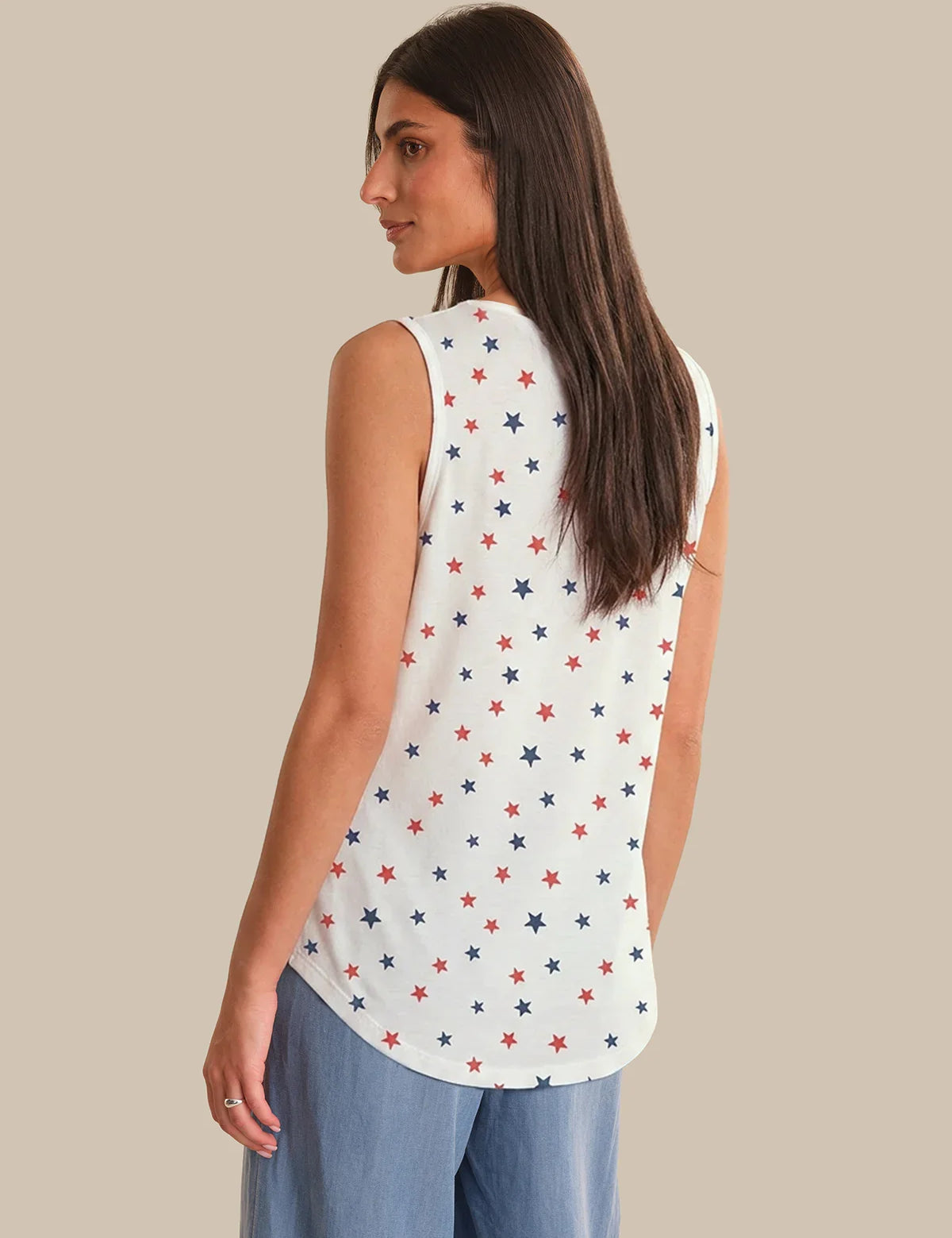 Woman wearing a sleeveless top with star pattern on a beige background