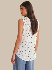 Woman wearing a sleeveless top with star pattern on a beige background