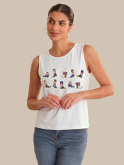 Woman wearing a white sleeveless shirt with colorful boot designs on a beige background