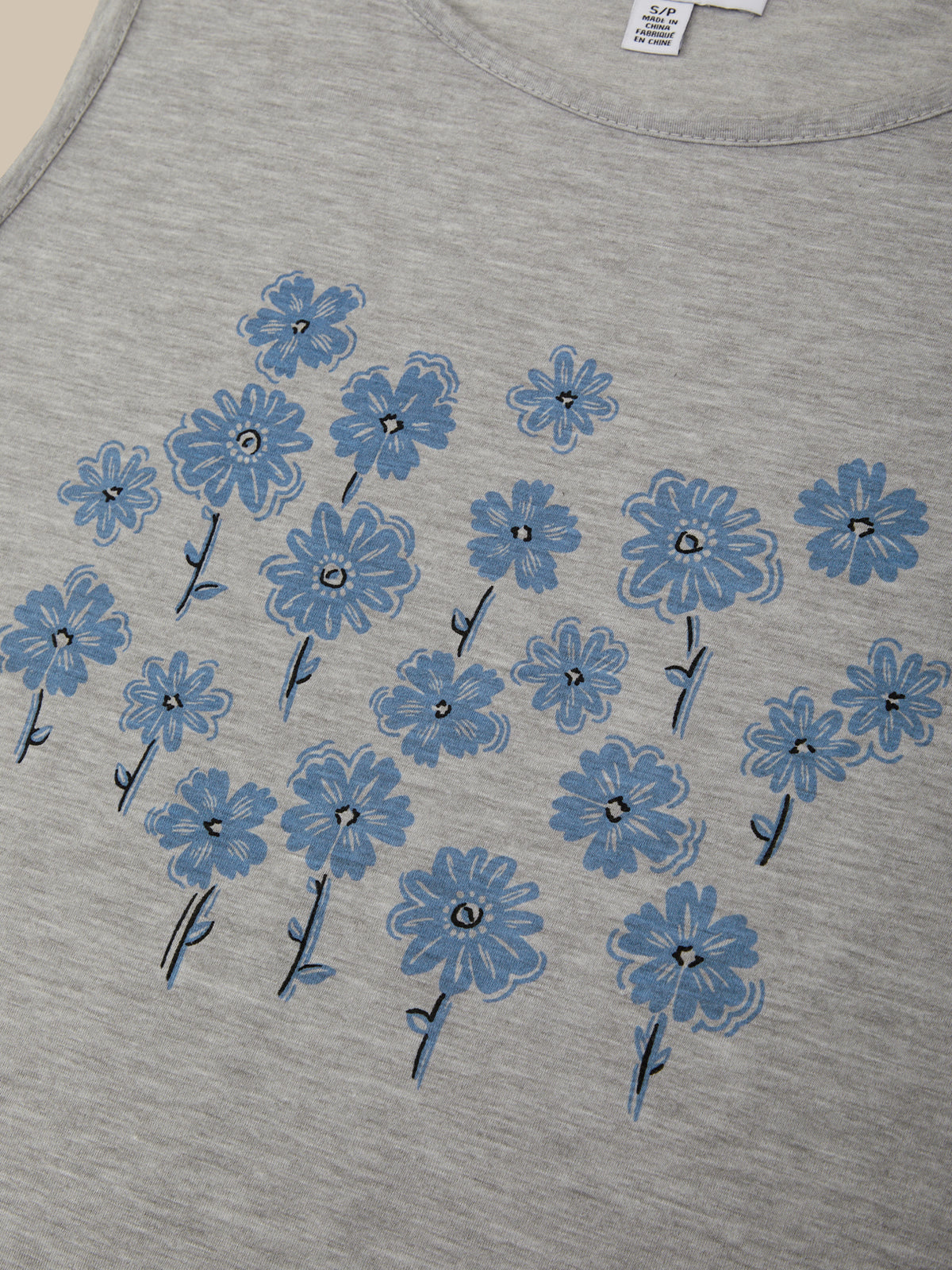 Gray t-shirt with blue floral patterns on a plain background