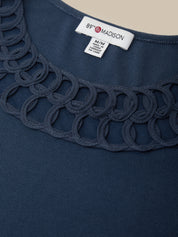Navy blue garment with scalloped edge and 'Madison' label on a beige background